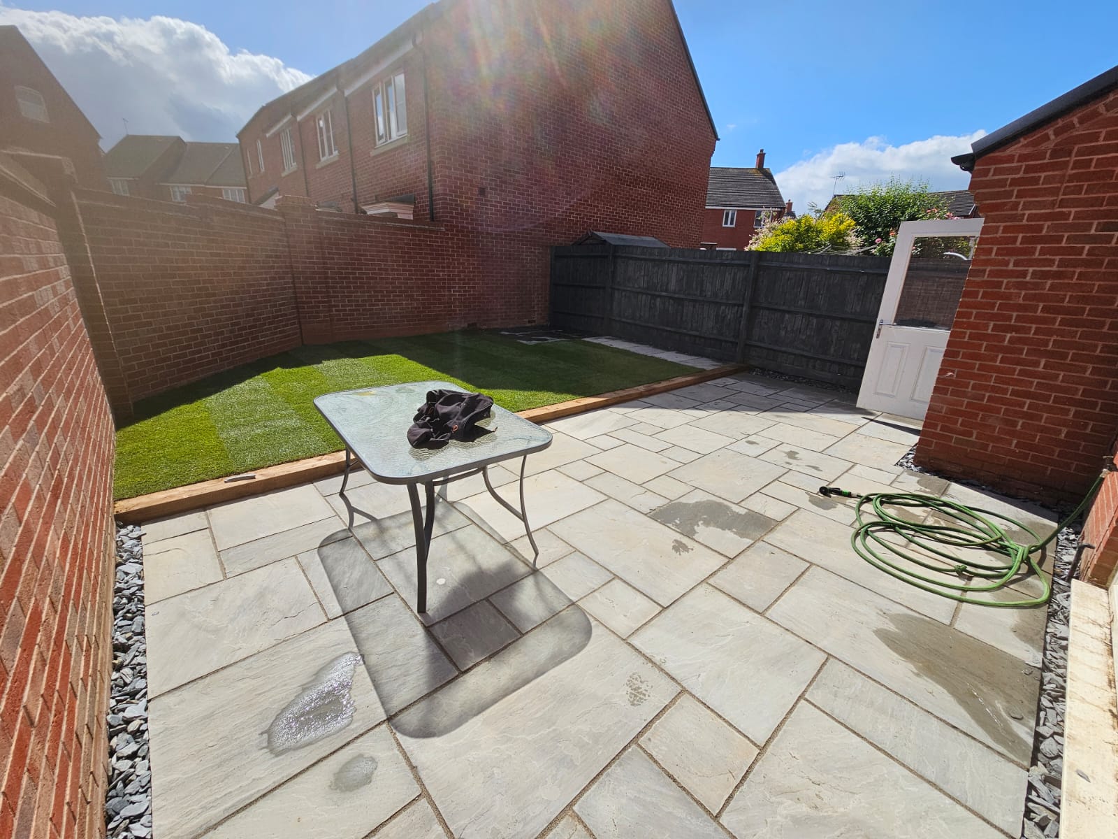 Sandstone patio with lawn area by Boyde Landscaping.